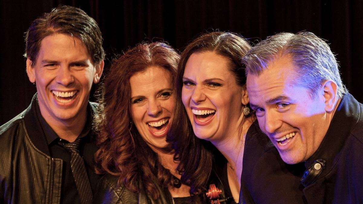 Four adults smiling at the camera